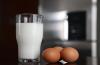 Fotografía de un vaso con leche y tres huevos en su cascarón